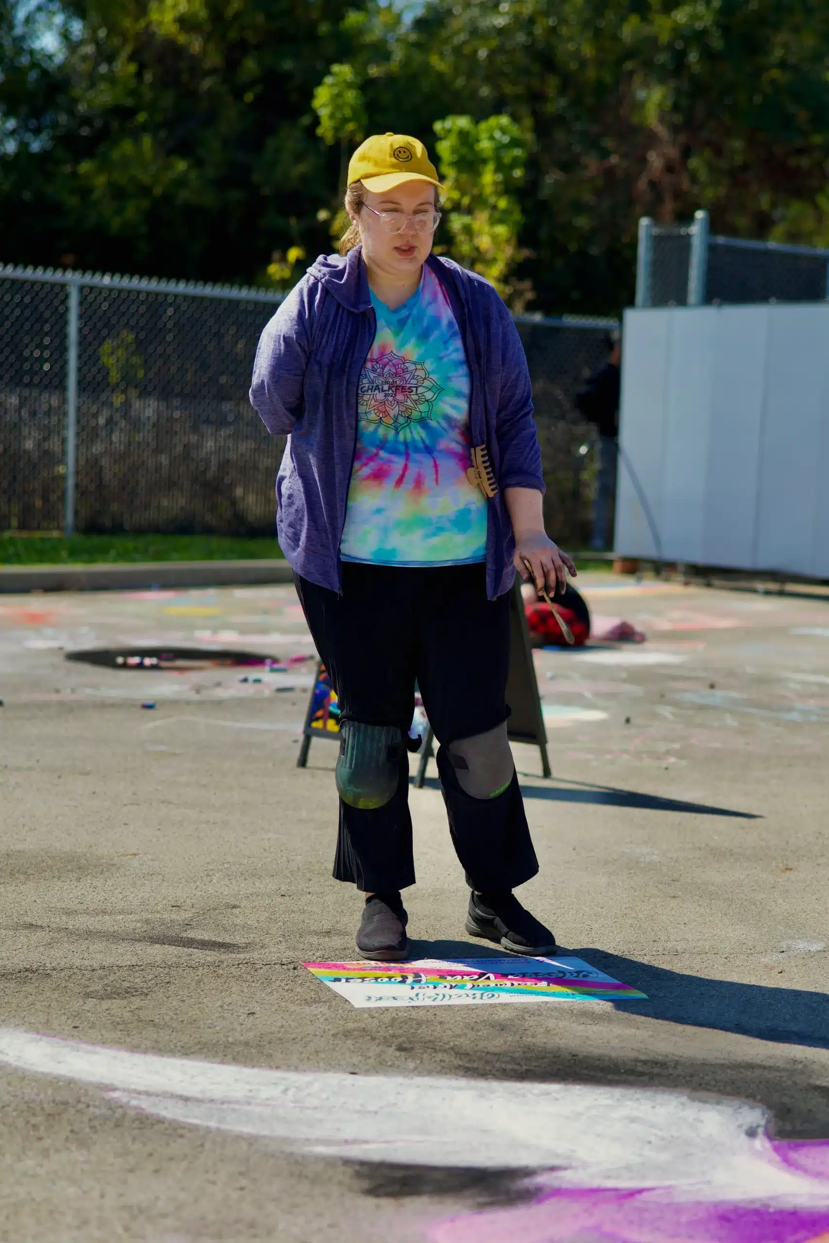 Person painting on pavement outdoors.