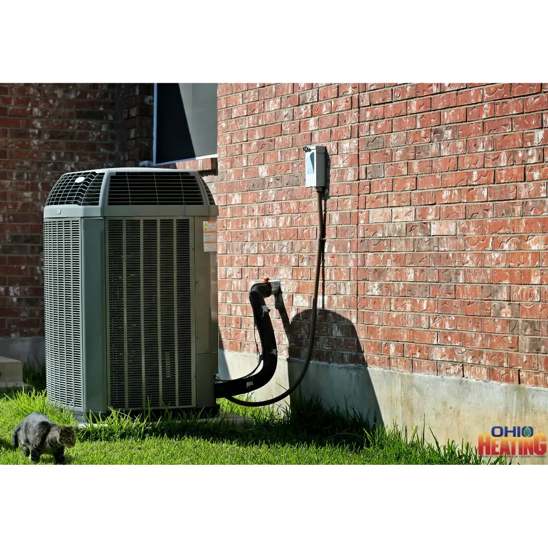 Outdoor residential AC condenser beside a brick home with Ohio Heating branding