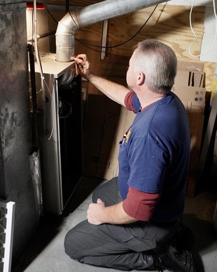 Ohio Heating technician checking the flue connection on a residential furnace while looking for cracked heat exchanger symptoms in Columbus